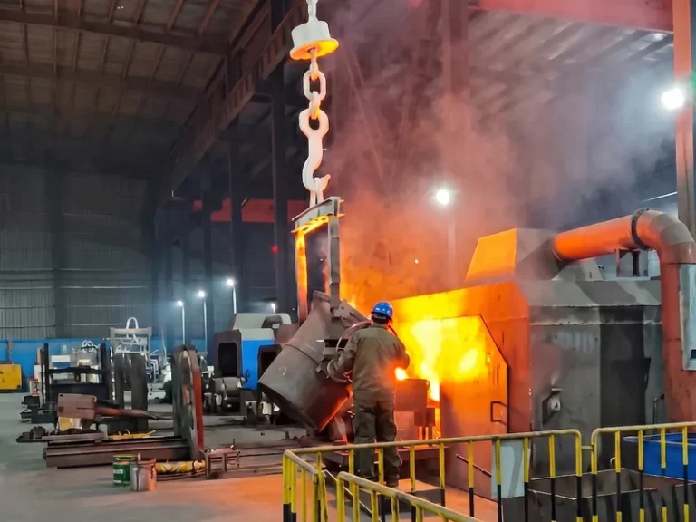 Worker performing precise molten metal pouring from a ladle into a horizontal centrifugal casting machine under strict safety protocols