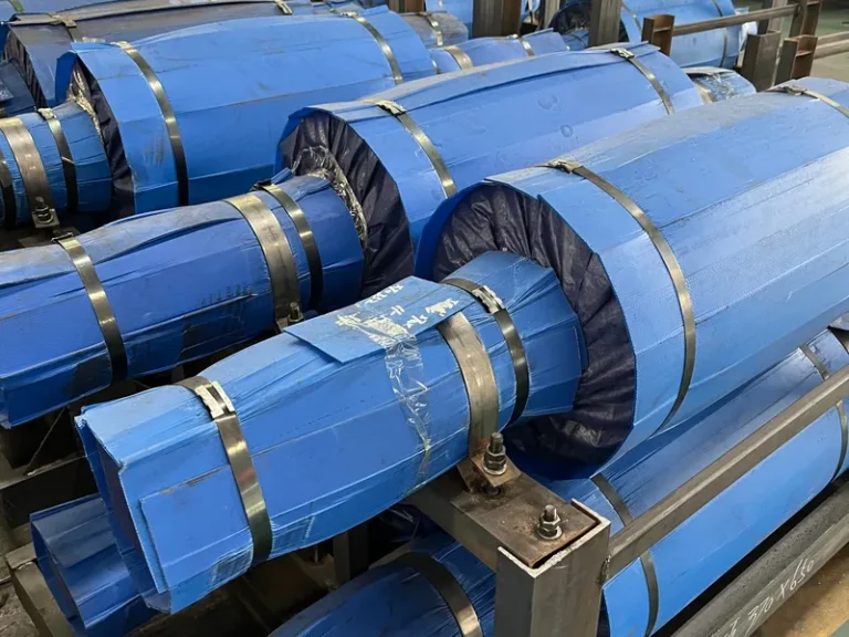 Close-up of the export-standard packaging for DURON mill rolls, featuring VCI anti-rust wrapping, heavy-duty steel strapping, and custom steel cradles.