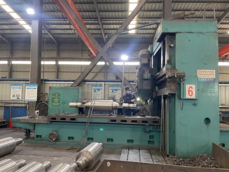A heavy-duty gantry milling machine processing the flat drive ends of a large metallurgical mill roll in the DURON manufacturing facility.