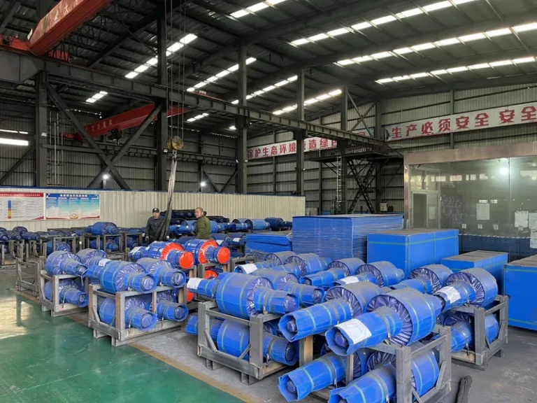 Wide view of the DURON dispatch area showing finished mill rolls and blue protective outer packaging shells being prepared for safe ocean freight.