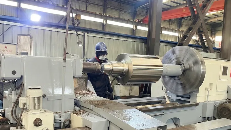 Quality engineer using a precision CNC lathe to machine a custom cast mill roll, ensuring rigorous dimensional tolerances for rolling mills.