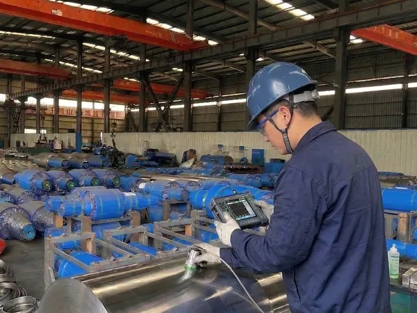 Certified technician performing ultrasonic non-destructive testing (NDT) on a finished cast mill roll to detect internal flaws